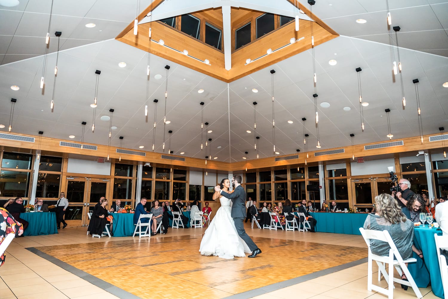 Danada house atrium before the renovations in 2024 with a couple slow dancing on the old wood floor centerpiece.
