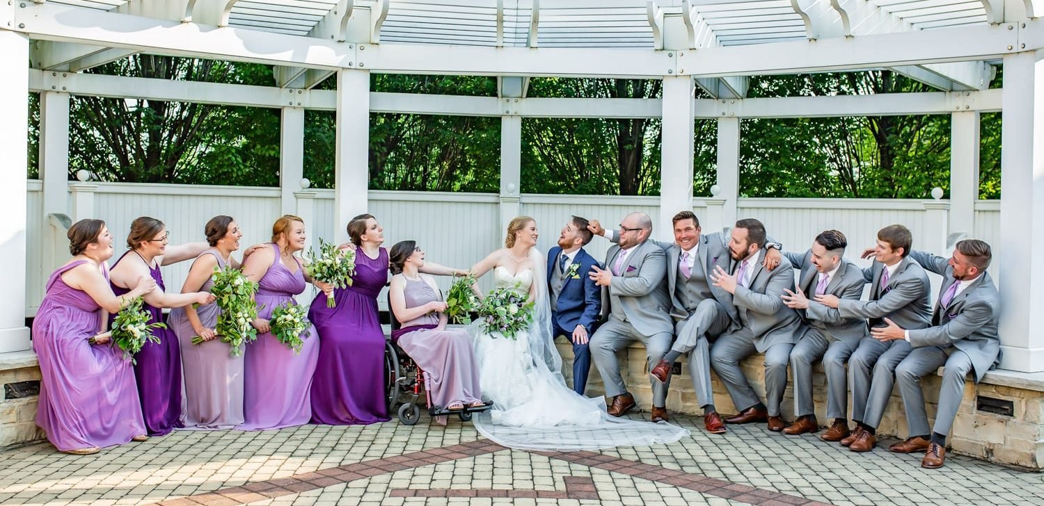 A bride, bridesmaids, groom and groomsmen in the saddle up wedding ceremony location at the historic danada house