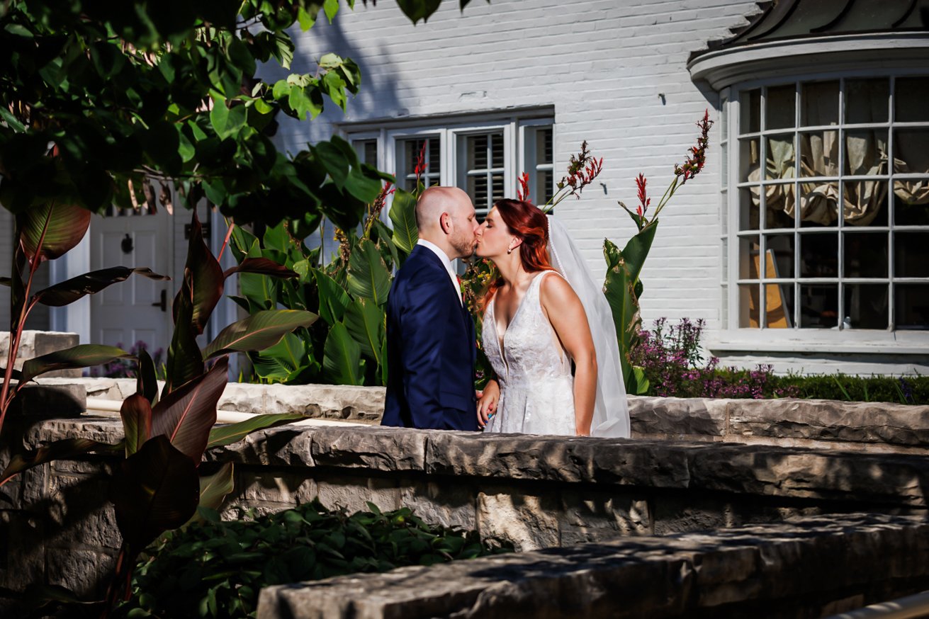 A man and woman kissing in front of a building