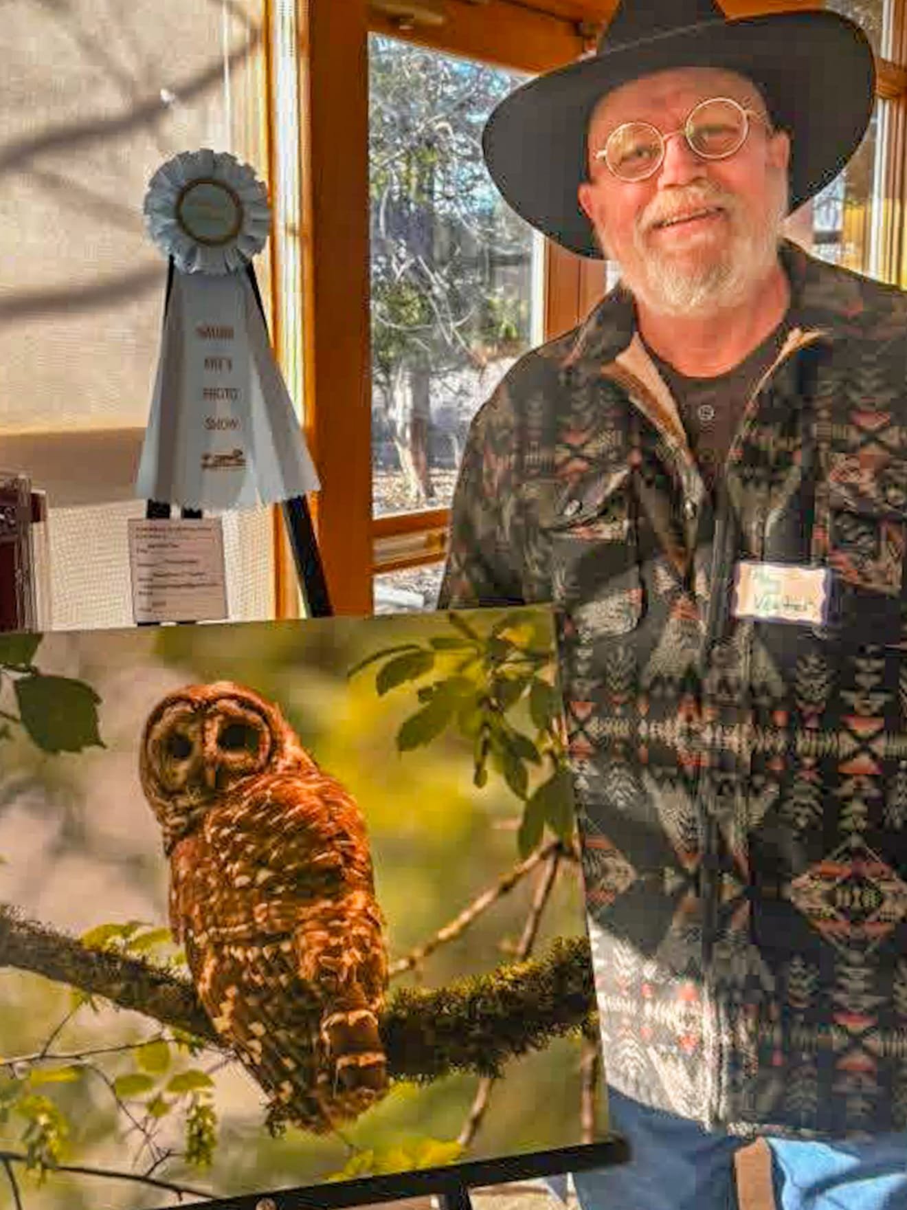 Raymond vegter standing with his barred owl photograph and honorable mention ribbon
