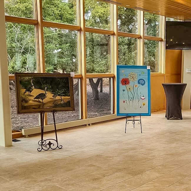 Two large paintings on easels by the danada house windows