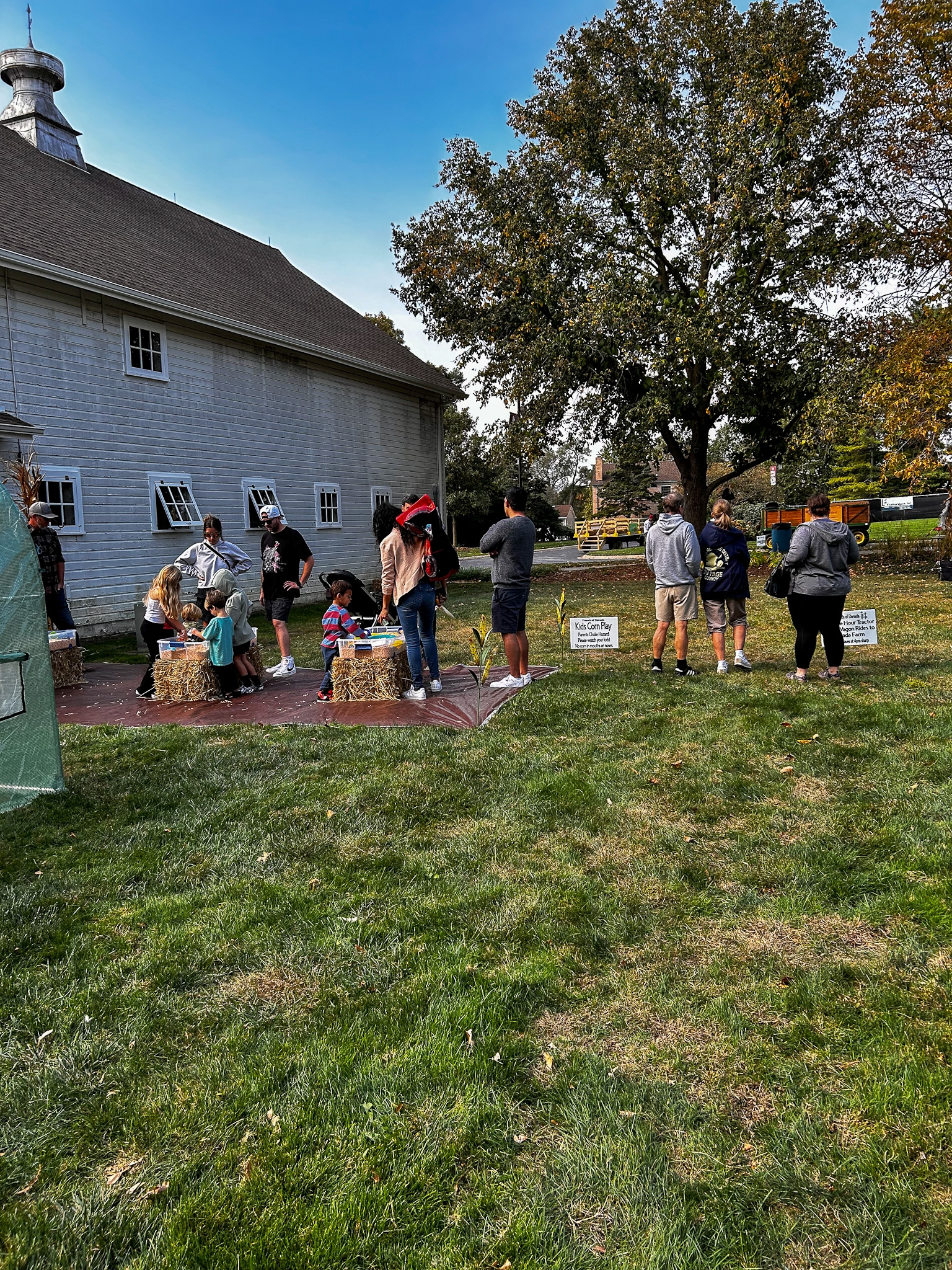 Festival visitors near the kids corn play area beside the barn