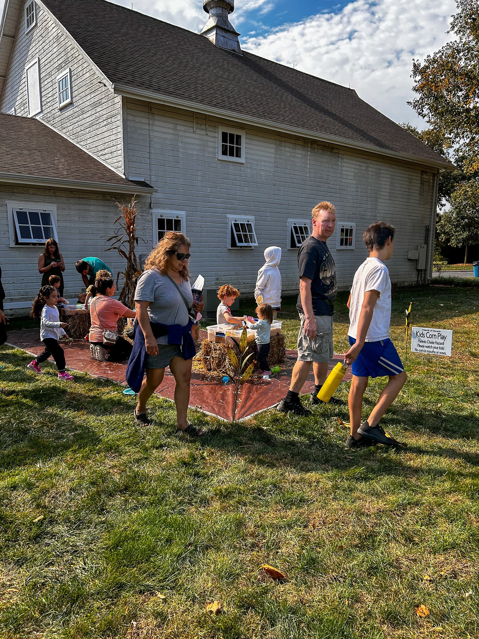 Families walking beside the kids corn play area near the danada barn