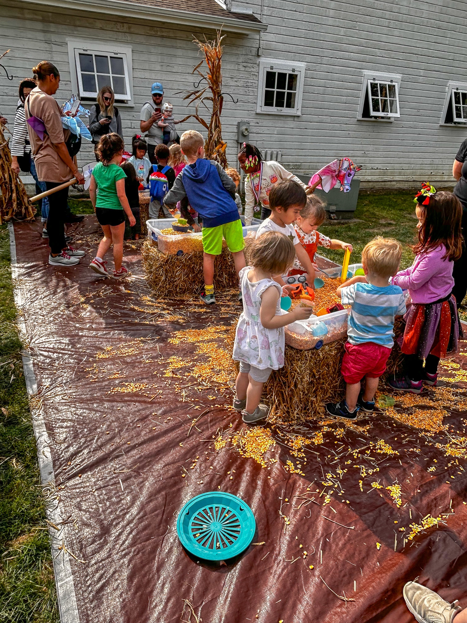 Children gathered around corn play activity bins during a previous festival